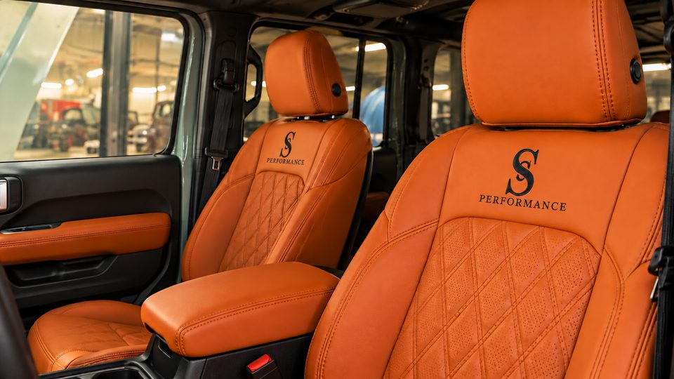 Interior: asientos de cuero naranja con la S de la marca